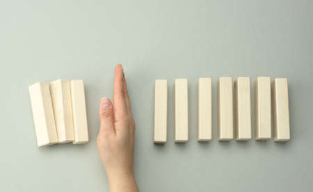 a woman's hand between the wooden blocks prevents most of it from falling. The concept of insurance,...