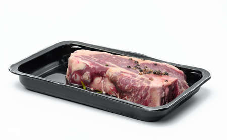 Raw New York beef steak is packed in a plastic container and vacuum sealed. Long-term storage...