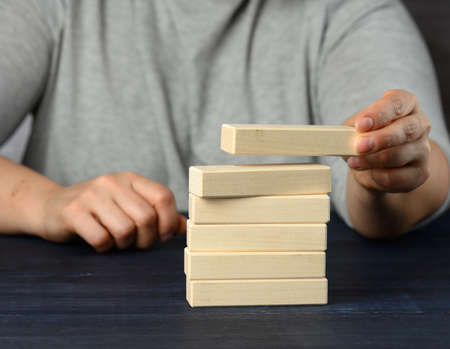 female hand puts wooden blocks on top of each other. Goal planning concept, new knowledge, strategy and managementの写真素材