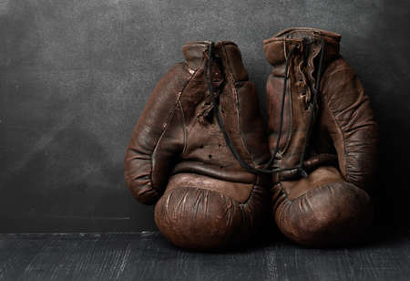 brown leather vintage boxing gloves on a black background, sports equipmentの写真素材