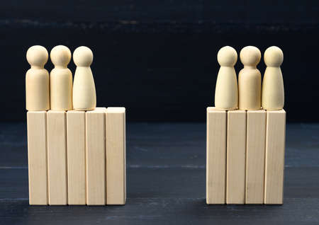 groups of wooden figures of men stand opposite each other. Conflict of interest concept, dialogue...