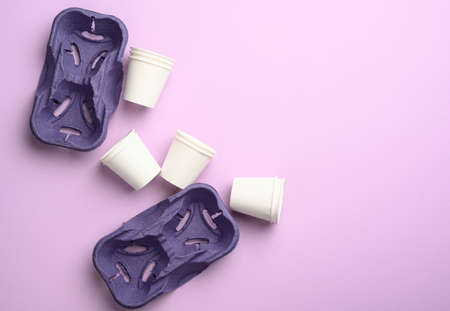 purple recycled paper cup holders and white paper cups, top view, zero wasteの写真素材