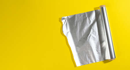roll of twisted food foil for packaging food on yellow background, top viewの写真素材