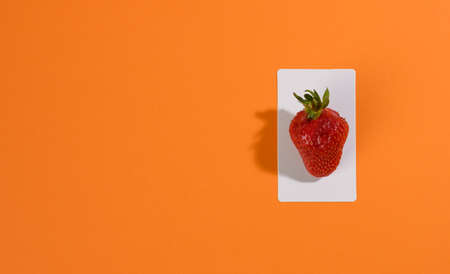 red ripe strawberries on an orange background, flat ayの写真素材