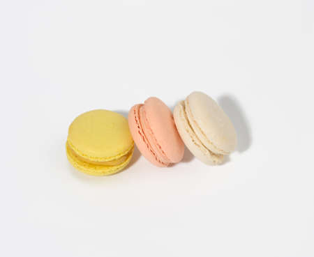 round multicolored macarons on a white background with a shadow. Gourmet almond flour dessert, top...