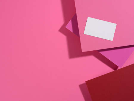 blank rectangular business card lies on a modern pink background sheets of paper with a shadow. Business template, flat layの写真素材