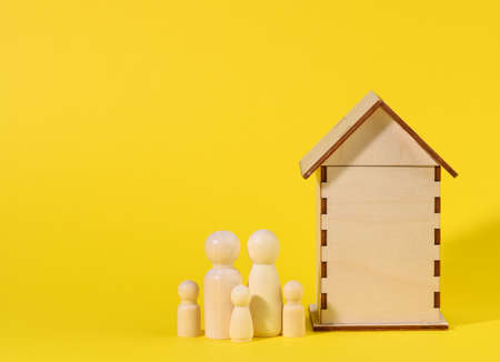 wooden family figurines, model house. Real estate purchase, rental concept. Moving to new apartments, copy spaceの写真素材