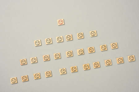 wooden blocks with figures on a gray background, hierarchical organizational structure of management, effective management model in the organization, top viewの写真素材