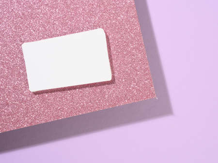 blank rectangular business card lies on a modern purple background sheets of paper with a shadow....
