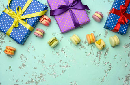 various gift boxes with tied bows and baked pasta on a green background, top viewの写真素材