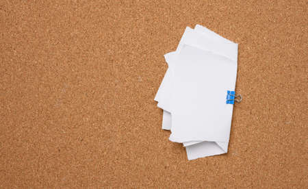 white blank paper sheets bound with a clip on brown backgroundの写真素材