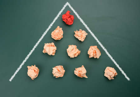 crumpled balls of paper are lined up in a wedge, moving forward. The concept of collecting innovative ideas in a team for productive workの写真素材