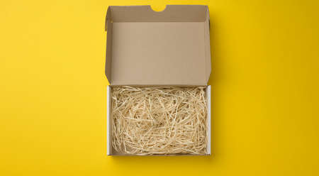 rectangular open corrugated paper box with sawdust inside. Packaging, containers for transportation...