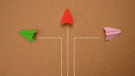 three paper airplanes fly in different directions on a brown background. Concepts of decisions, disunity of thinking, choiceの写真素材
