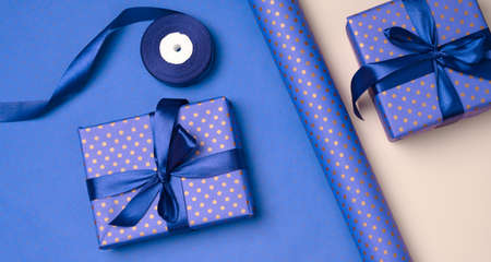 blue gift box wrapped in silk ribbon on a bluee background, top viewの写真素材
