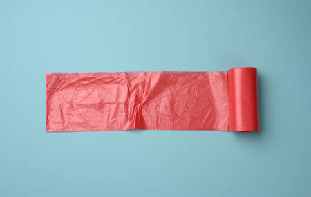 roll of red transparent plastic bags for trash can on blue background, top viewの写真素材