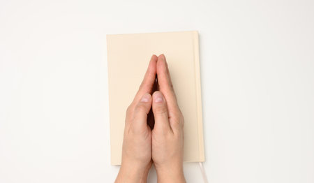 two female hands in a prayer pose on a white background, top viewの写真素材
