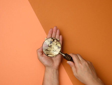 wooden men and a magnifying glass on a brown background. Recruitment concept, search for talented and capable employees, career growthの写真素材