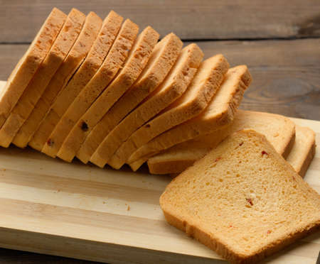 sliced white wheat flour bread on a wooden board. Sandwich bread