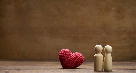 pair of wooden men of the bride and groom, red heart, brown background, concept of love and relationships. Copys paceの写真素材