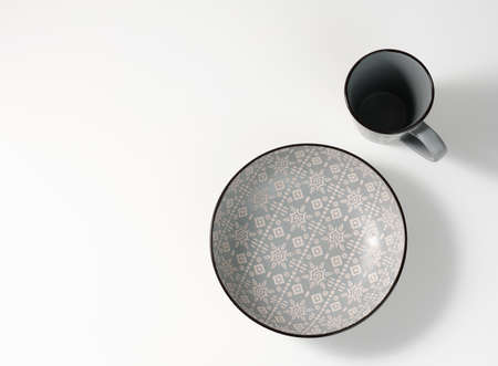 empty gray ceramic soup plate and empty cup on white table, utensils