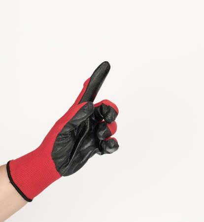hand in a black-red textile work glove points with the index finger to the side on white