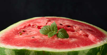 ripe red watermelon. Black background, close up