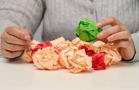 female hand holds a crumpled green ball of paper. New idea, brainstormingの写真素材