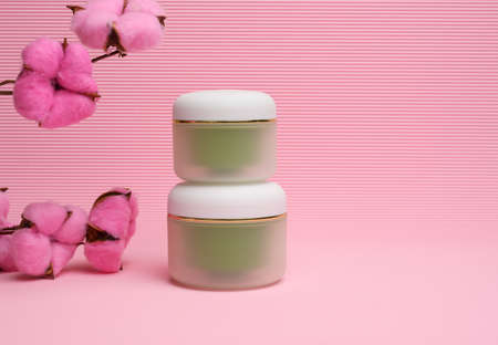 green jar for cosmetics on a pink background. Packaging for cream, gel, serum, advertising and product promotion, mock upの写真素材