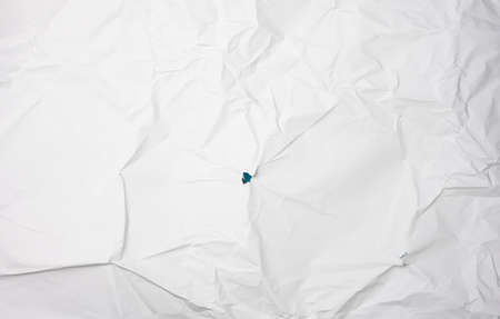 crumpled white paper, creases and a holeの写真素材