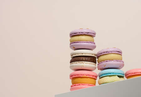 baked round macarons on a beige background, delicious dessert, bottom view
