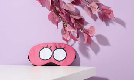pink textile sleep mask on white table