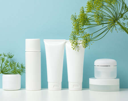 empty white plastic tubes and jars for cosmetics. Packaging for cream, gel, serum, advertising and product promotion, mock upの写真素材