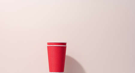 paper cardboard red cups for coffee, beige background. Eco-friendly tableware, zero wasteの写真素材