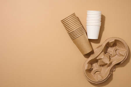 paper brown disposable cardboard cup and holder on brown background. View from above