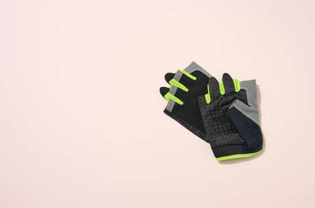 pair of black sports gloves for doing sports and riding bike on a beige background, top viewの写真素材