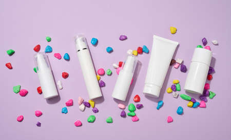 jar, bottle and empty white plastic tubes for cosmetics on a purple background. Packaging for cream, gel, serum, advertising and product promotion, mock upの写真素材