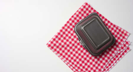 closed gray disposable container and a red napkin on a white table, top viewの写真素材