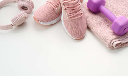 pair of textile purple sports sneakers, wireless headphones, a towel on a white background. Sportswearの写真素材