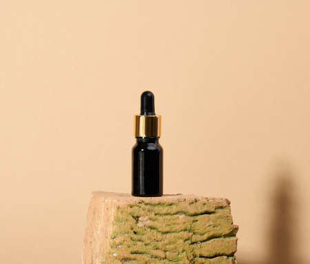 brown glass bottle with pipette stands on a white table. Cosmetics SPA branding. Packaging for gel, serum, advertising and product promotion, mock upの写真素材