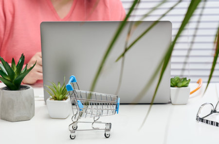 empty miniature shopping carts on white desk. Seasonal sale, online shoppingの写真素材