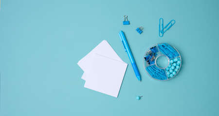 stack of white square sheets of paper for notes, stationery on blue background, top view
