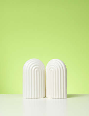 podium with white arches to showcase cosmetics, products and other merchandise. Green background