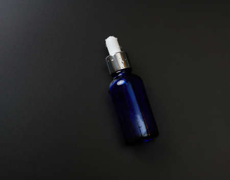 blue glass bottle pipette on a black background. Pharmacy concept. Collagen skin. Mockup skincare cosmetic productの写真素材