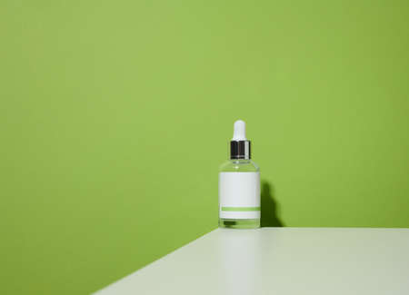 white glass bottle with a pipette and a empty white label. Container for cosmetics, serum and oil. Mockup skincare productの写真素材