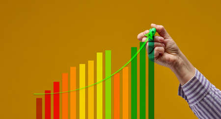 female hand with green marker and multicolored graph on yellow background. Performance growth...