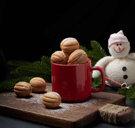 baked nut-shaped dessert in a red ceramic mug sprinkled with powdered sugar