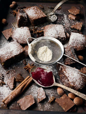 baked square pieces of chocolate brownie sprinkled with powdered sugar on the tableの写真素材