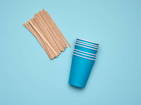 stack of blue paper cups on a blue background. Plastic rejection concept, zero waste, top view