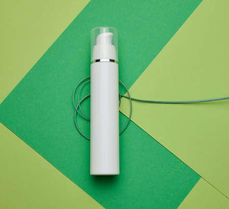 empty white plastic bottle on a green background. Cosmetic products for branding gel, cream, lotion, shampoo. Mock up eco cosmeticsの写真素材